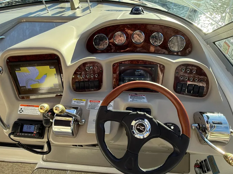 Slide: The Image of 2007 Sea Ray 340 Sundancer helm with navigation system and wood-accented steering wheel. - 3