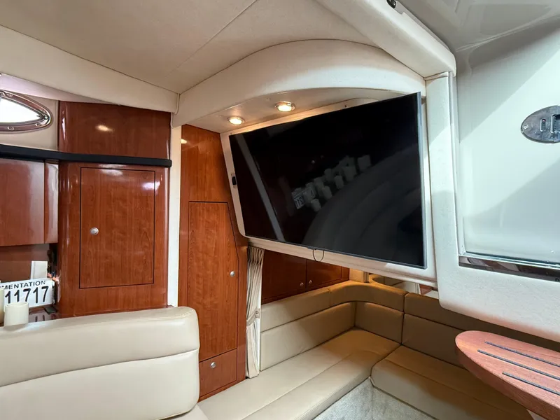 Slide: The Image of Interior of 2007 Sea Ray 340 Sundancer with TV, wood cabinets, and beige seating. - 30