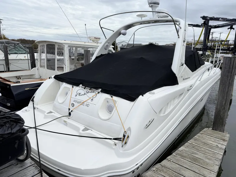 Slide: The Image of 2007 Sea Ray 340 Sundancer docked, covered with black tarp, in marina setting. - 8