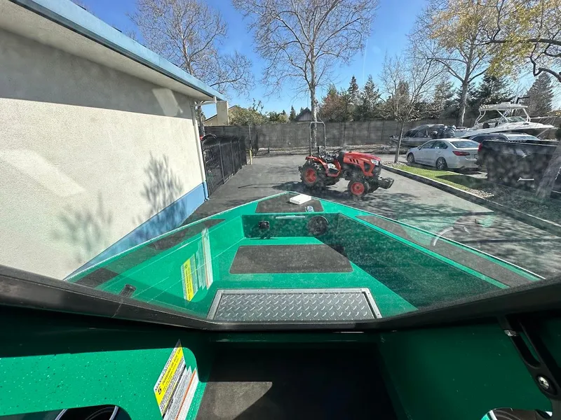 Slide: The Image of 2023 Weldcraft 18 Angler Sport boat parked, view from cockpit, with tractor and cars nearby. - 32