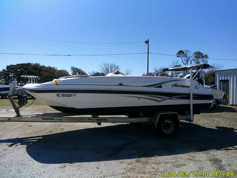 Slide: The Image of 2006 Hurricane Fun Deck 194 boat on trailer, parked outdoors under clear sky. - 2