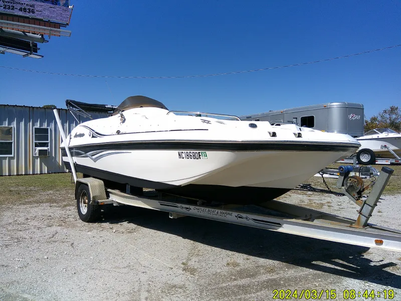 Slide: The Image of 2006 Hurricane Fun Deck 194 boat on trailer, parked outdoors under clear blue sky. - 6