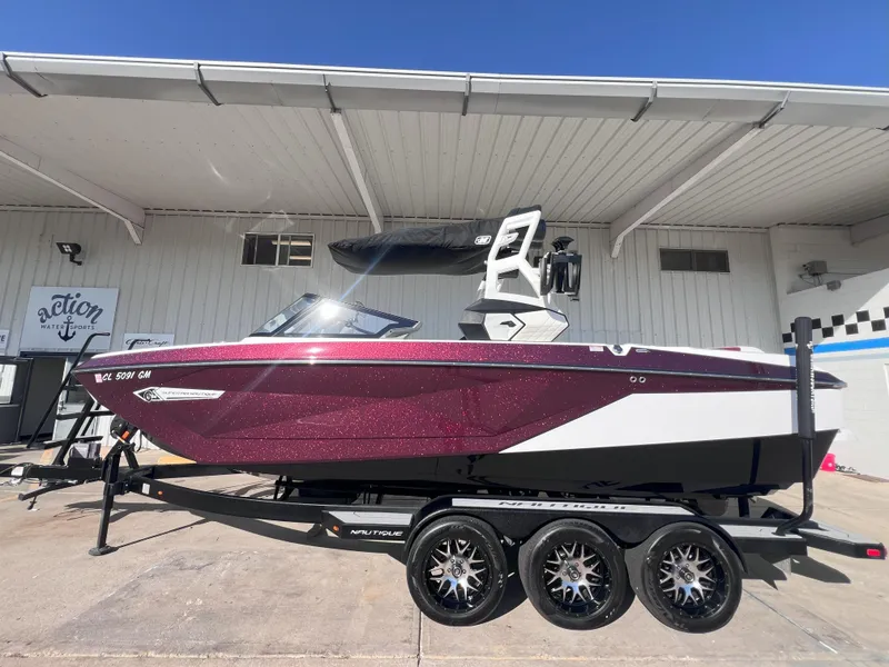 Slide: The Image of 2021 Nautique Super Air G23 boat on trailer, vibrant red and white design. - 1