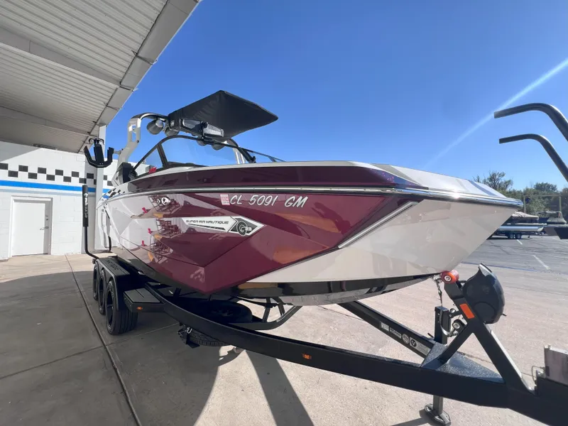 Slide: The Image of 2021 Nautique Super Air G23 boat on trailer, parked outdoors under clear sky. - 4
