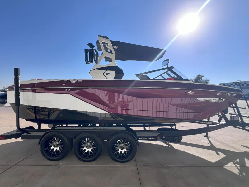 Slide: The Image of 2021 Nautique Super Air G23 boat on trailer under bright sun. - 5