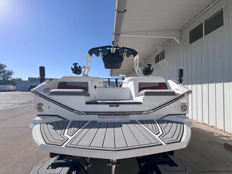 Slide: The Image of 2021 Nautique Super Air G23 boat, rear view, parked outdoors under a white canopy. - 8