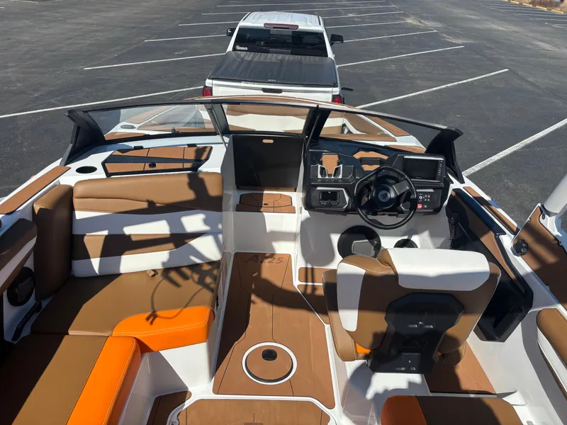 Slide: The Image of Interior view of a 2025 Axis A225 boat with brown and orange seating. - 4