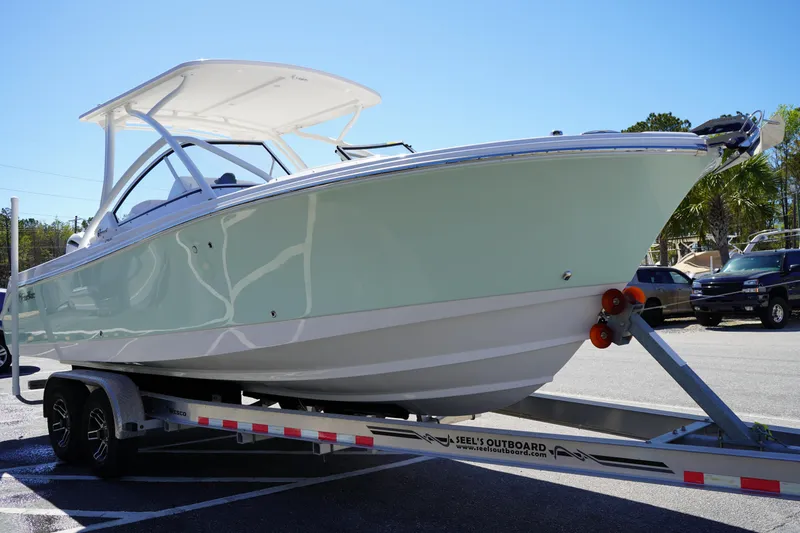 Slide: The Image of 2025 Edgewater 248 CX boat on trailer, parked outdoors under clear blue sky. - 1