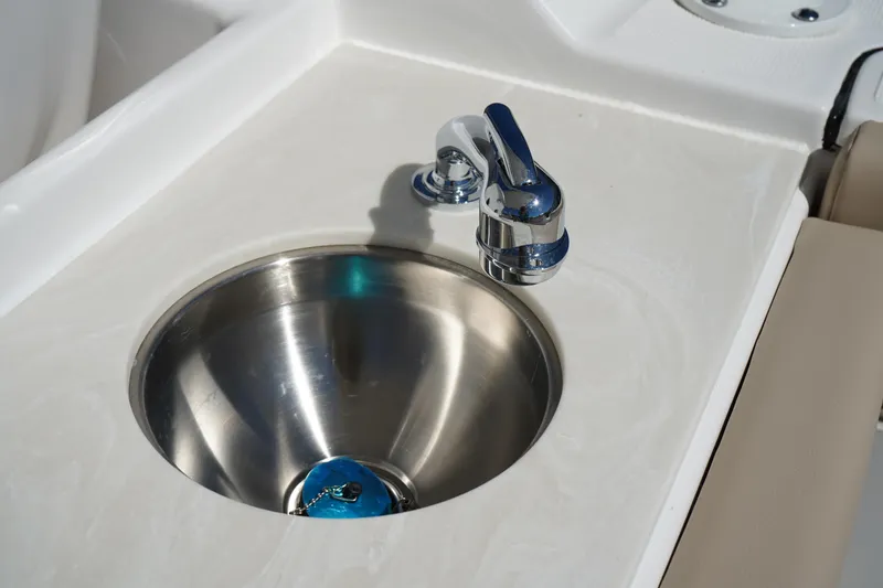 Slide: The Image of 2025 Edgewater 248 CX boat sink with round cover and faucet. - 17