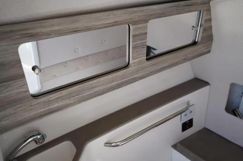 Slide: The Image of 2025 Edgewater 248 CX boat interior with compact marine toilet and sleek design. - 23