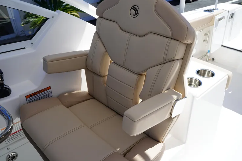 Slide: The Image of 2025 Edgewater 248 CX boat seat with beige upholstery and cup holders. - 26
