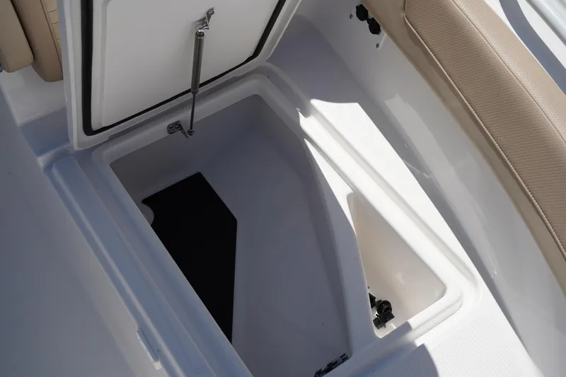 Slide: The Image of 2025 Edgewater 248 CX boat interior with beige seating and storage compartment. - 33