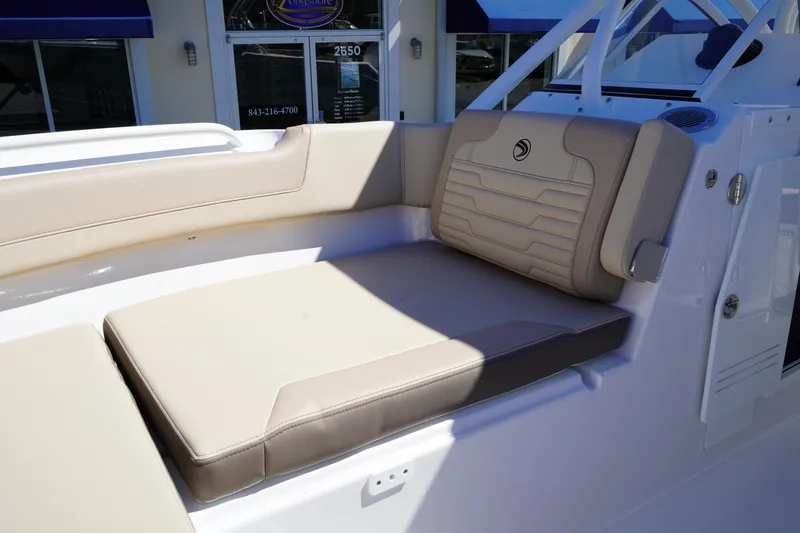 Slide: The Image of 2025 Edgewater 248 CX boat interior with beige cushioned seating. - 36
