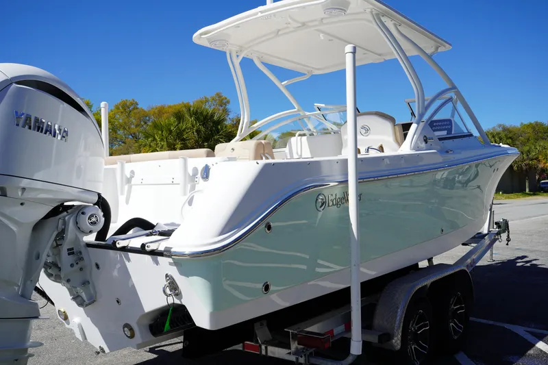 Slide: The Image of 2025 Edgewater 248 CX boat with Yamaha engine on trailer, parked outdoors. - 5