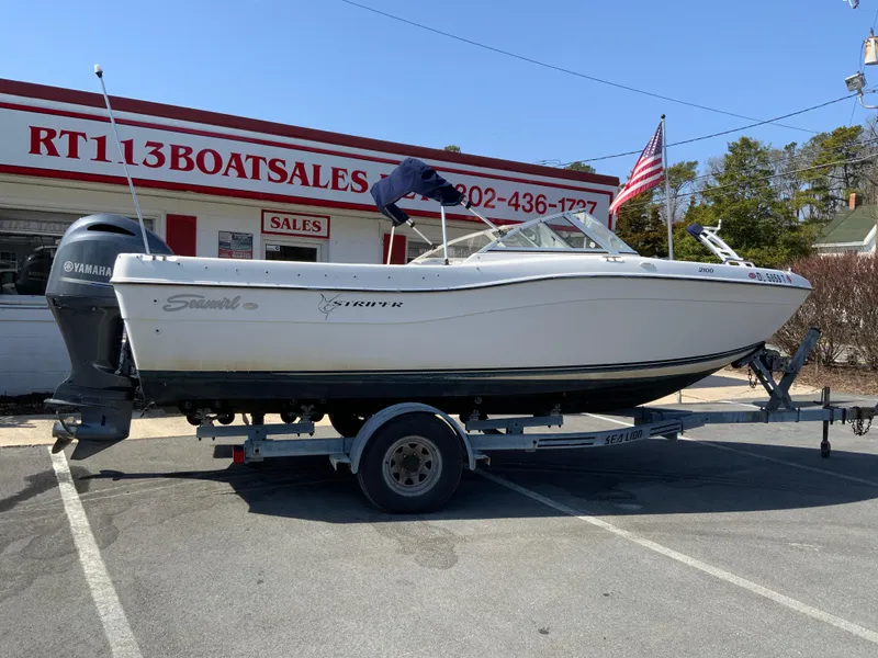 Slide: The Image of 1997 Seaswirl Striper 2100 DC boat on trailer at dealership, with Yamaha outboard motor. - 1
