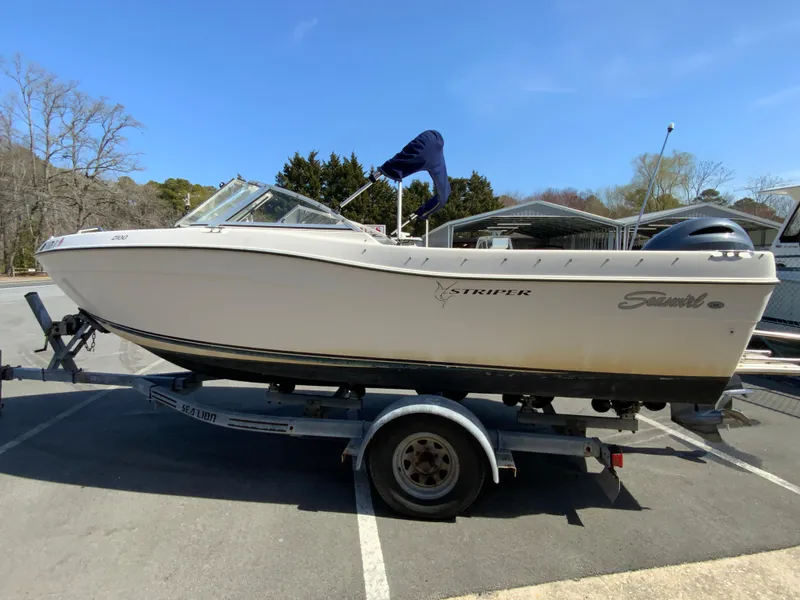 Slide: The Image of 1997 Seaswirl Striper 2100 DC boat on trailer, parked outdoors. - 6