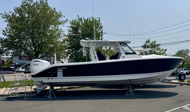Slide: The Image of 2025 Pursuit S 328 boat displayed outdoors on stands. - 1