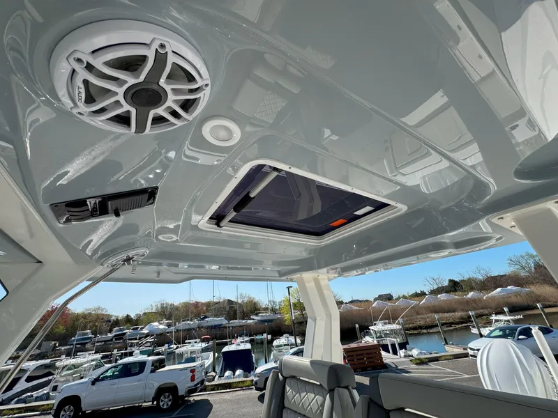 Slide: The Image of 2025 Pursuit S 328 boat interior with speaker and sunroof, docked at marina. - 22