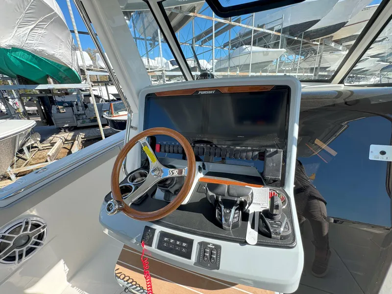 Slide: The Image of Helm of 2025 Pursuit S 328 boat with steering wheel and control panel. - 26