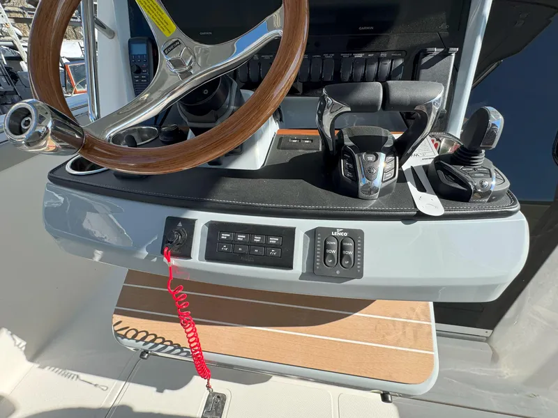 Slide: The Image of Control panel of 2025 Pursuit S 328 boat with steering wheel and throttle controls. - 27