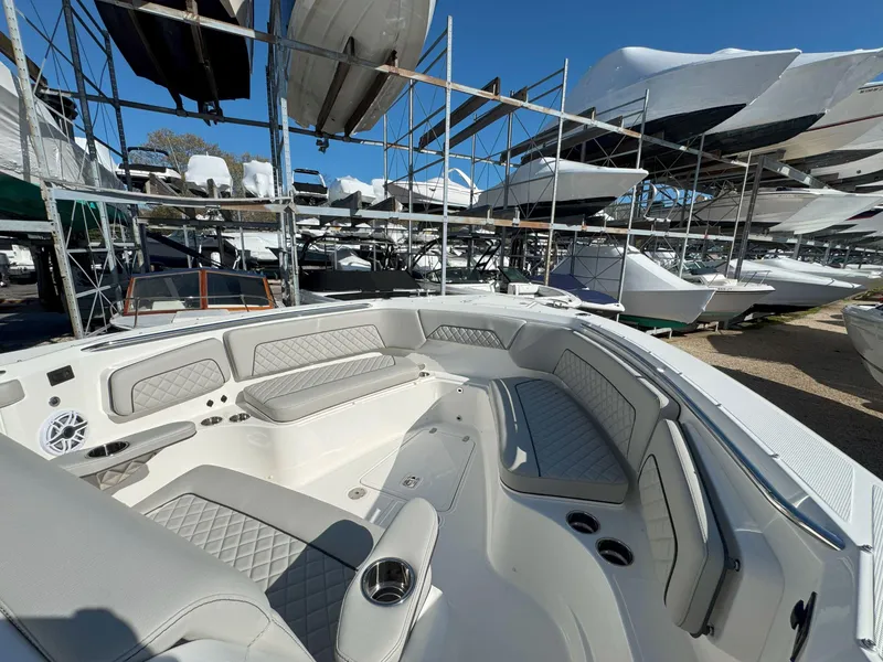 Slide: The Image of 2025 Pursuit S 328 boat interior with luxurious seating, docked among other boats. - 32