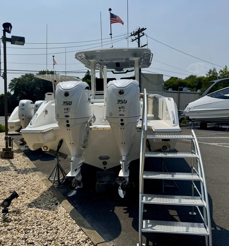 Slide: The Image of 2025 Pursuit S 328 boat with twin 350 engines, docked with American flag in background. - 4
