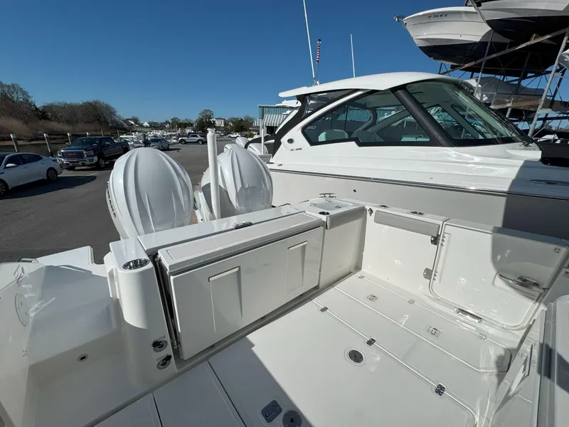 Slide: The Image of 2025 Pursuit S 328 boat with dual engines, docked under clear blue sky. - 8