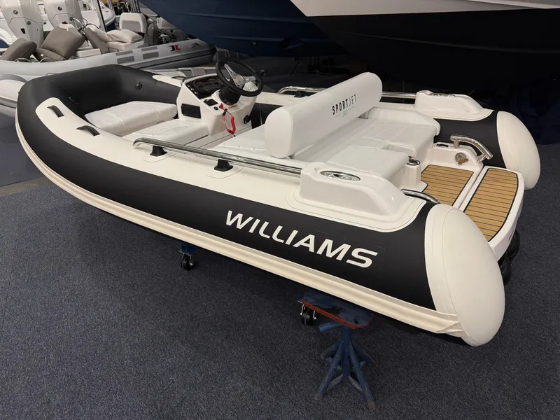 Slide: The Image of 2024 Williams Jet Tenders Sportjet 345, sleek design, displayed indoors on a stand. - 4