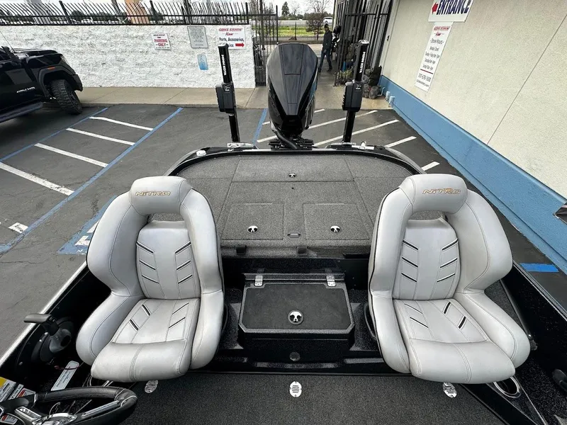 Slide: The Image of Two gray seats on a 2021 Nitro Z20 Pro boat in a parking lot. - 11