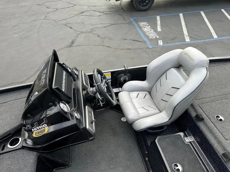 Slide: The Image of Nitro Z20 Pro 2021 boat cockpit with steering wheel and seat, parked on asphalt. - 12