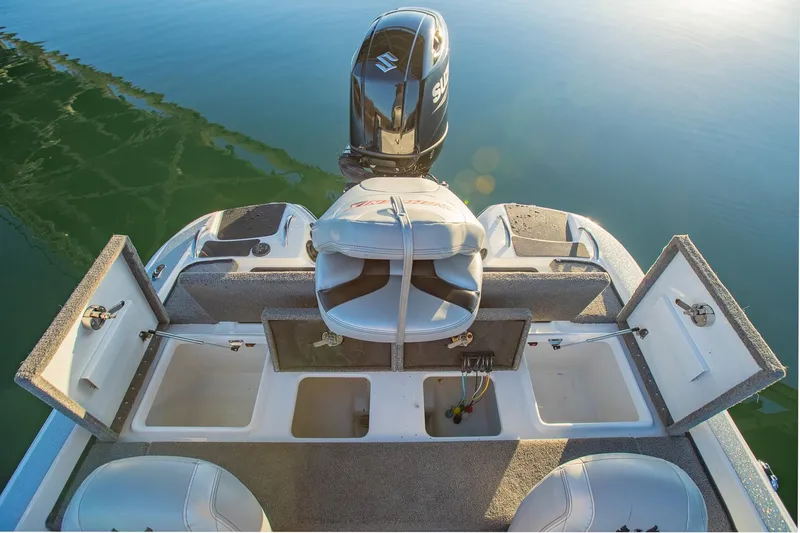 Slide: The Image of 2017 Phoenix 618 Pro boat with open storage compartments and Suzuki outboard motor on calm water. - 16