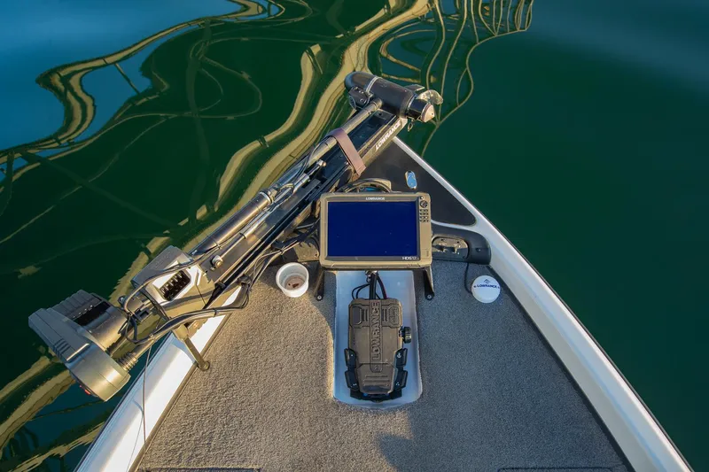 Slide: The Image of Phoenix 618 Pro 2017 boat deck with navigation equipment and trolling motor on calm water. - 28
