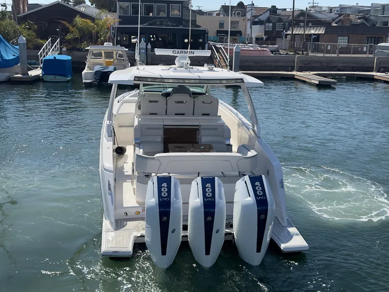 Slide: The Image of 2023 Tiara Yachts 38LS with triple outboard engines docked in a marina. - 3