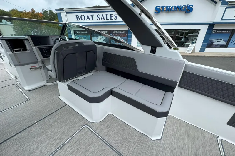 Slide: The Image of Interior of 2025 Cobalt R33 OB boat at dealership, featuring modern seating and dashboard. - 11