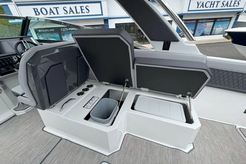 Slide: The Image of 2025 Cobalt R33 OB boat interior with open storage compartments at a yacht sales location. - 12