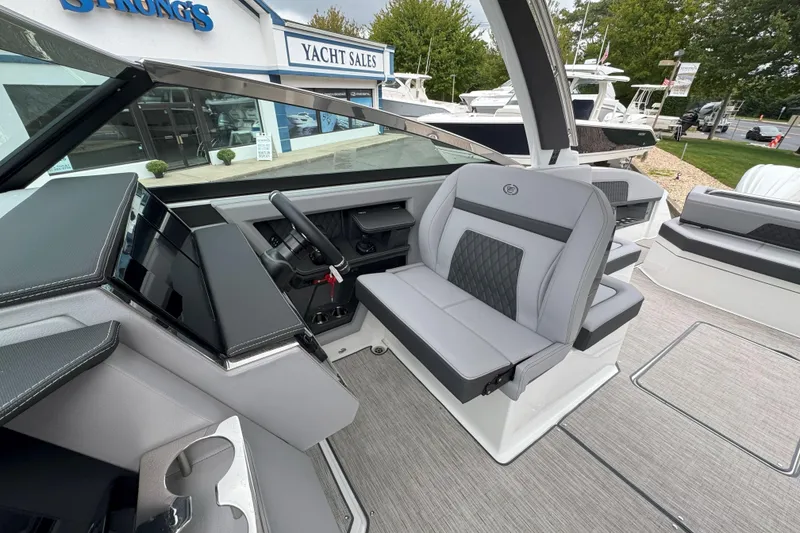 Slide: The Image of 2025 Cobalt R33 OB boat interior at yacht sales, featuring modern seating and dashboard. - 14