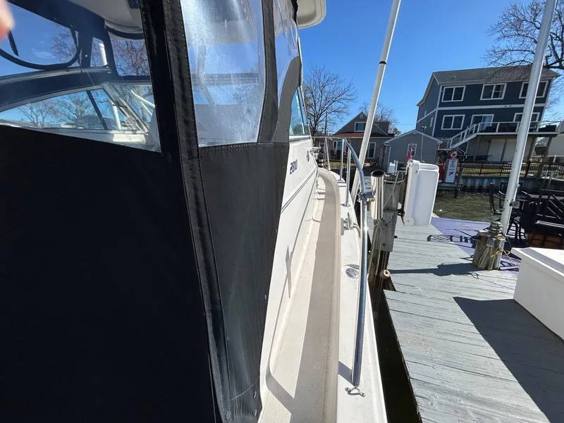 Slide: The Image of 1997 Pro-Line 2810 Walkaround boat docked, side view with clear skies. - 12