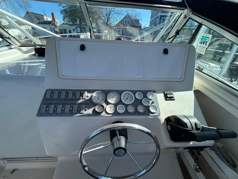 Slide: The Image of 1997 Pro-Line 2810 Walkaround boat dashboard with steering wheel and gauges. - 14