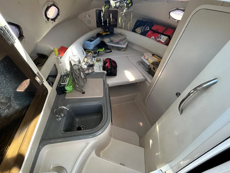 Slide: The Image of 1997 Pro-Line 2810 Walkaround cabin interior with sink, storage, and seating area. - 21