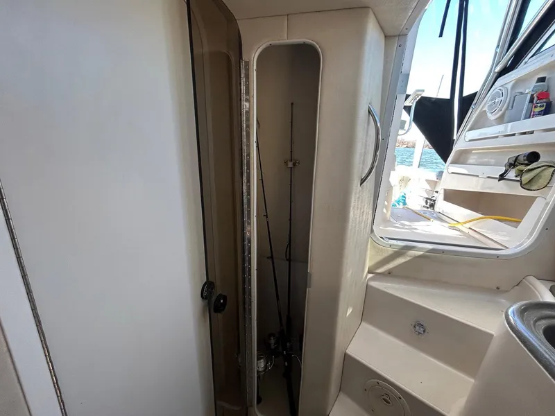 Slide: The Image of 1997 Pro-Line 2810 Walkaround interior with fishing rod storage and steps to deck. - 25
