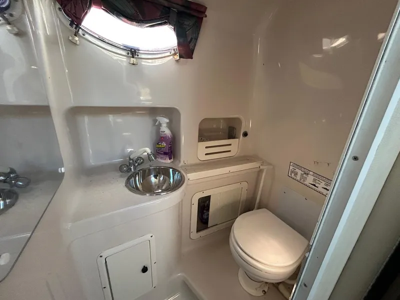 Slide: The Image of 1997 Pro-Line 2810 Walkaround boat bathroom with sink and toilet. - 26