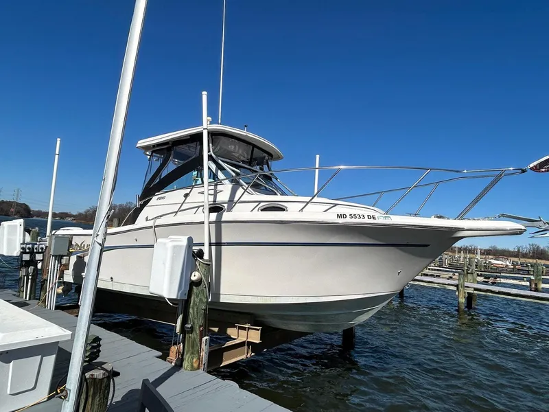 Slide: The Image of 1997 Pro-Line 2810 Walkaround boat docked at marina under clear blue sky. - 3