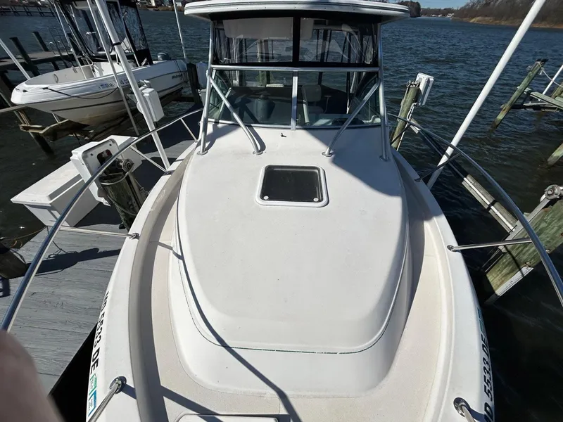 Slide: The Image of 1997 Pro-Line 2810 Walkaround boat docked, featuring a spacious deck and windshield. - 31