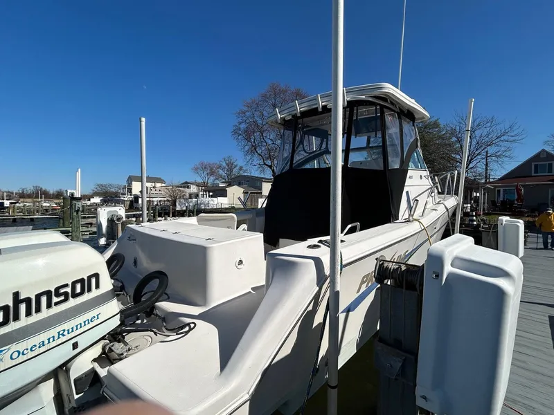 Slide: The Image of 1997 Pro-Line 2810 Walkaround boat docked, featuring Johnson OceanRunner outboard motor. - 4