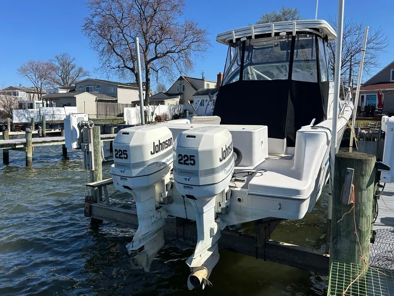 Slide: The Image of 1997 Pro-Line 2810 Walkaround boat with twin Johnson 225 engines docked at marina. - 7