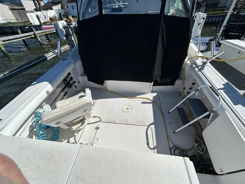 Slide: The Image of 1997 Pro-Line 2810 Walkaround boat interior with seating and equipment, docked by the water. - 9