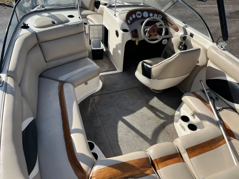 Slide: The Image of 2000 Tigé 2100V Limited boat interior with beige seating and wood accents. - 2