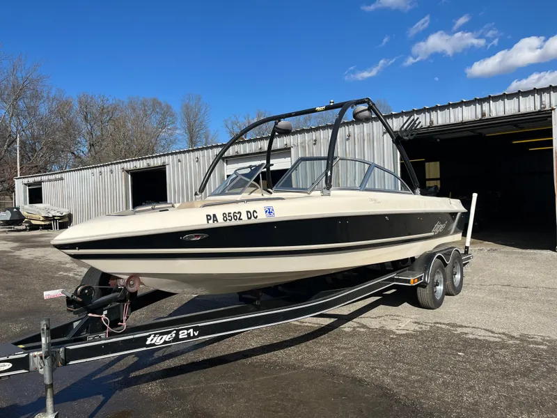 Slide: The Image of 2000 Tigé 2100V Limited boat on trailer, parked outside a warehouse. - 8