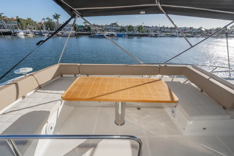 Slide: The Image of Flybridge seating area on a 2019 Absolute 45 FLY yacht, overlooking a marina. - 32