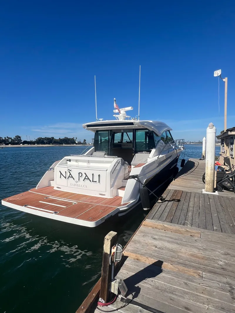 Slide: The Image of 2021 Tiara Yachts 53 Coupe docked at a marina under clear blue skies. - 11